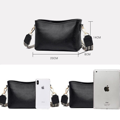 Sac à main noir en cuir avec bandoulière amovible, dimensions 20x14x8 cm, comparé à un iPhone et un iPad pour illustrer sa taille compacte.