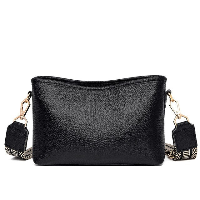 Sac à main en cuir noir texturé avec bandoulière réglable à motifs, fermoirs dorés. Accessoire mode élégant et tendance pour femme.
