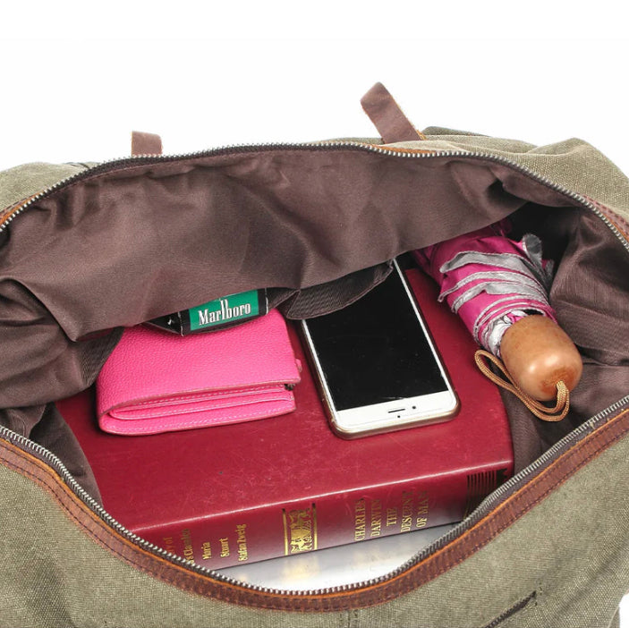 Sac ouvert avec livre rouge, portefeuille rose, téléphone, paquet de cigarettes Marlboro et parapluie. Accessoires de voyage essentiels.
