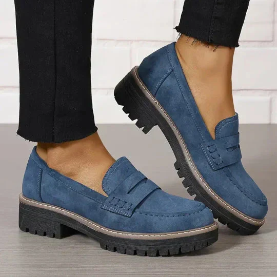 Chaussures mocassins bleues pour femmes, semelles épaisses, style décontracté, portées avec un pantalon noir. Mode féminine, tendance chaussures.