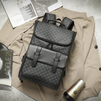 Sac à dos en cuir noir élégant sur un manteau beige, avec magazines et gobelet à café. Accessoire mode tendance pour homme, style urbain chic.