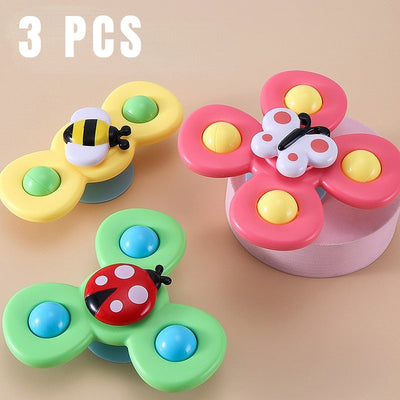 Trois jouets rotatifs en forme de papillon, abeille et coccinelle colorés pour enfants, sur fond beige. Jouets éducatifs et ludiques.