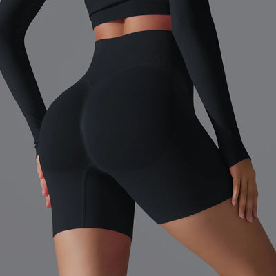 Femme portant un short de sport noir taille haute, mettant en valeur la silhouette. Vêtements de fitness, mode active, confort et style.