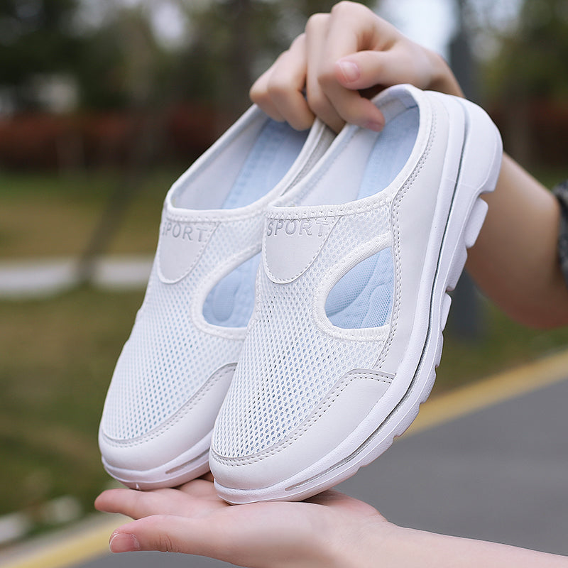Chaussures de sport blanches en maille respirante, légères et confortables, tenues en main. Idéales pour la marche et les activités extérieures.