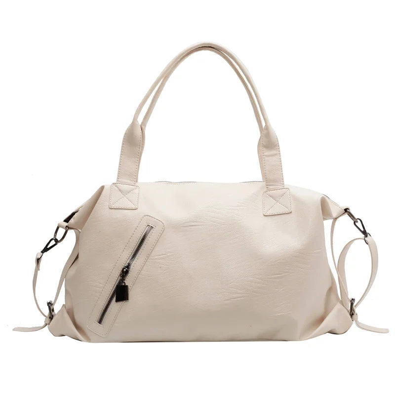 Sac à main en cuir blanc élégant avec poignées doubles, poche zippée avant et bandoulières amovibles. Accessoire mode femme chic et pratique.
