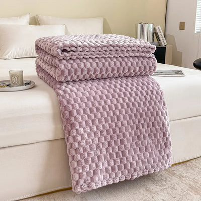Couverture en peluche violette sur un lit blanc, chambre moderne, décoration intérieure élégante, confort et style, accessoires de maison tendance.