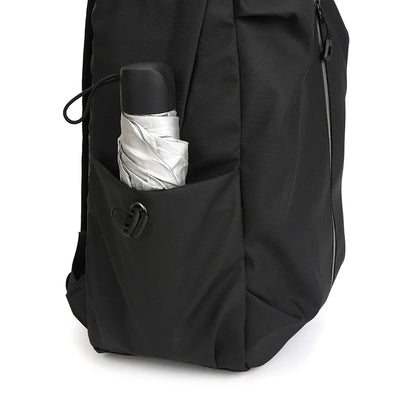 Sac à dos noir avec parapluie argenté dans la poche latérale. Accessoire pratique pour voyage, randonnée, usage quotidien. Design moderne et fonctionnel.