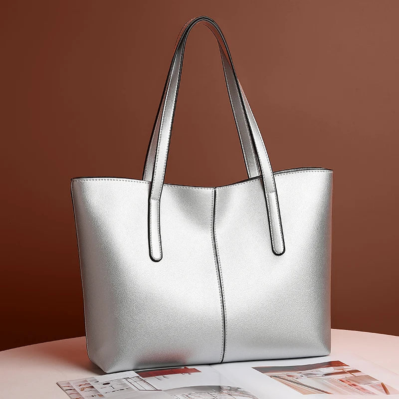 Sac à main en cuir argenté élégant sur fond marron, design moderne et minimaliste, parfait pour la mode féminine et les accessoires tendance.