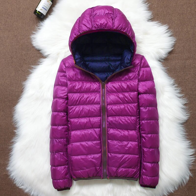 Doudoune violette à capuche sur tapis blanc, veste matelassée chaude, mode hiver, vêtement extérieur isolant, tendance féminine.