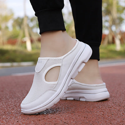 Chaussures de sport blanches pour femme sur une piste de course rouge. Design respirant avec semelle épaisse, idéales pour la marche et le jogging.