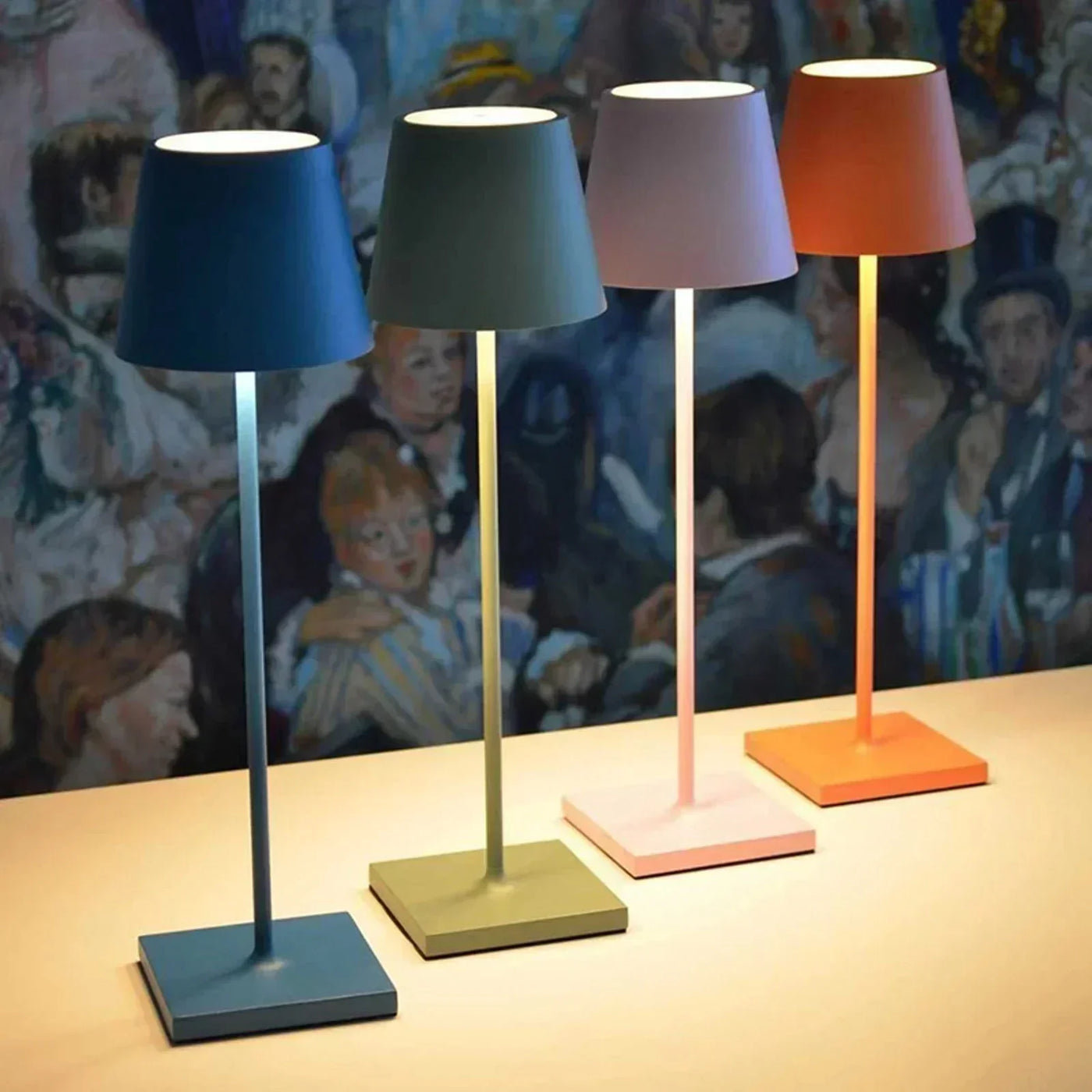 Quatre lampes de table modernes colorées sur une surface beige, avec un fond artistique. Éclairage design, décoration intérieure contemporaine.
