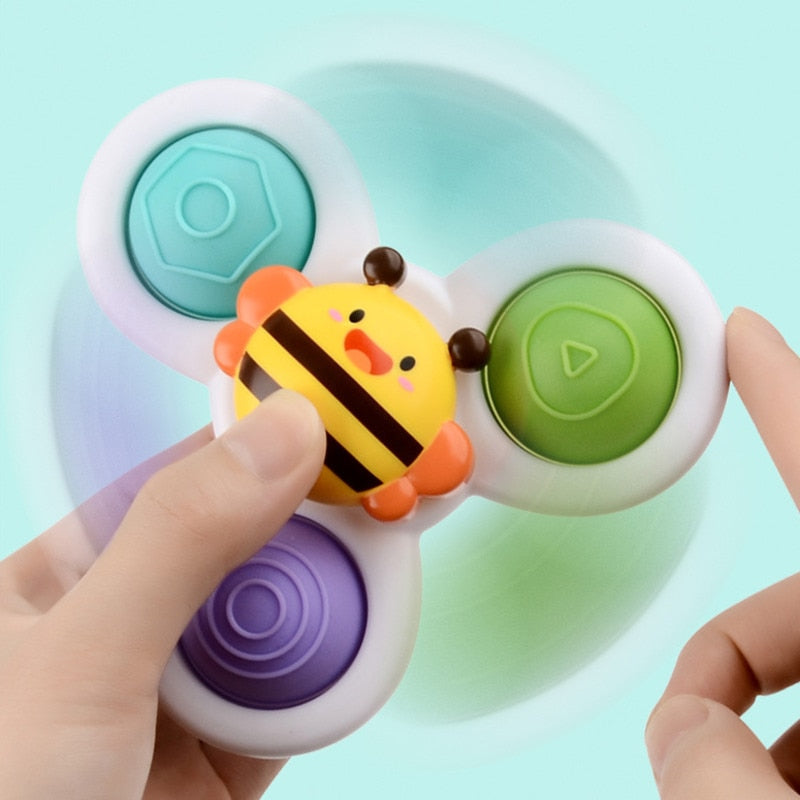 Fidget spinner enfant, design abeille, trois branches colorées, jouet anti-stress, fond bleu, mains d'enfant, jeu sensoriel populaire.