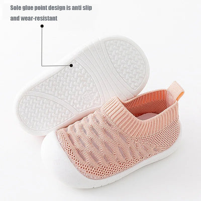 Chaussures bébé roses antidérapantes, semelle blanche texturée, design en maille respirante, confort et sécurité pour premiers pas.