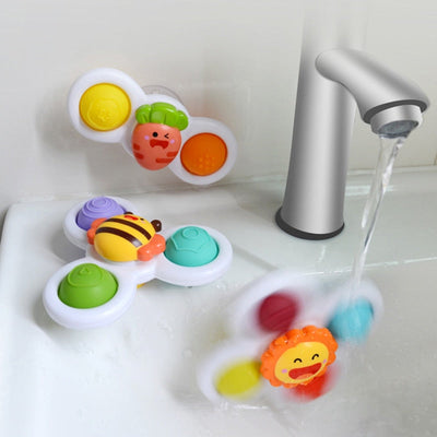 Jouets de bain pour enfants en forme de fleurs et d'animaux, fixés au mur près d'un robinet d'eau. Accessoires colorés et ludiques pour bain.