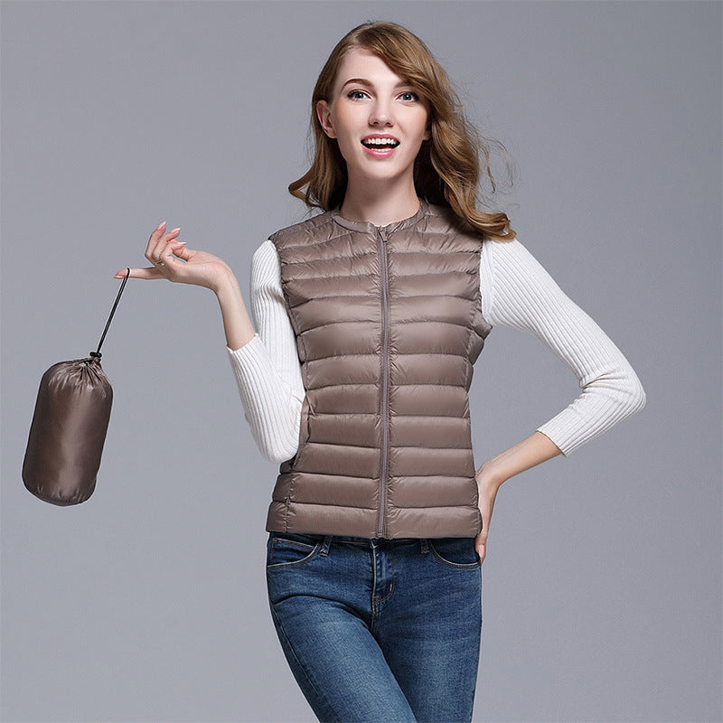 Femme portant une doudoune légère marron, manches longues blanches, tenant un sac de rangement. Mode automne, style décontracté, vêtements chauds.