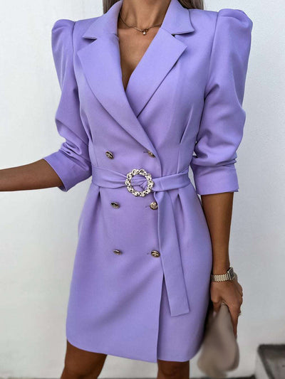 Robe blazer lilas élégante pour femme avec ceinture à boucle ornée, manches longues et épaulettes. Mode féminine chic et tendance.