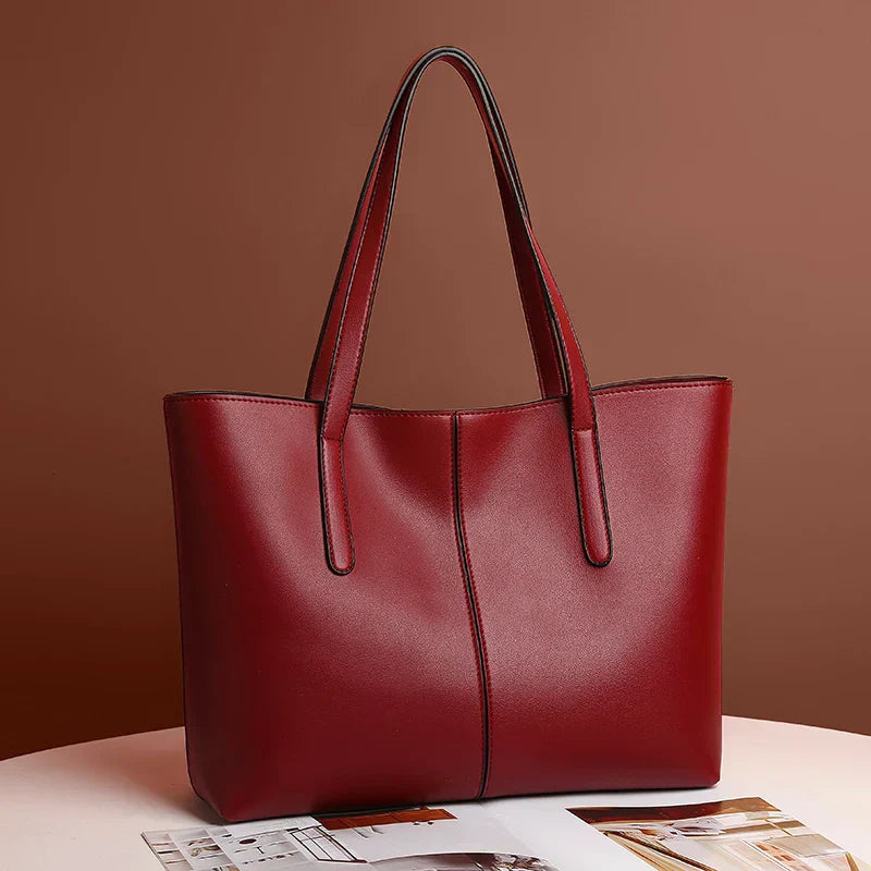 Sac à main en cuir rouge élégant sur fond marron, design moderne avec anses longues. Accessoire mode femme, parfait pour un look chic et tendance.
