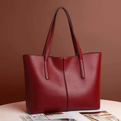 Sac à main en cuir rouge élégant sur fond marron, design moderne avec anses longues. Accessoire mode femme, parfait pour un look chic et tendance.