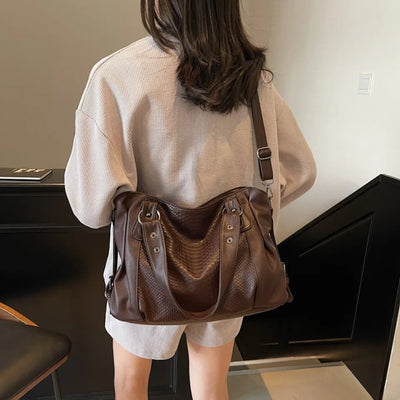 Femme portant un sac à main en cuir marron texturé, style décontracté, intérieur moderne. Mode féminine, accessoires tendance, élégance urbaine.