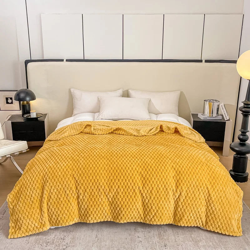 Lit moderne avec couvre-lit jaune texturé, oreillers blancs, tables de chevet noires, lampes design, chambre élégante et contemporaine.