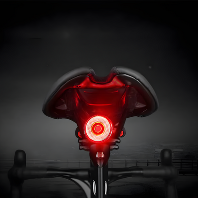 Selle de vélo avec feu arrière LED rouge allumé, sécurité cycliste, accessoire vélo nocturne, visibilité accrue, équipement cyclisme moderne.