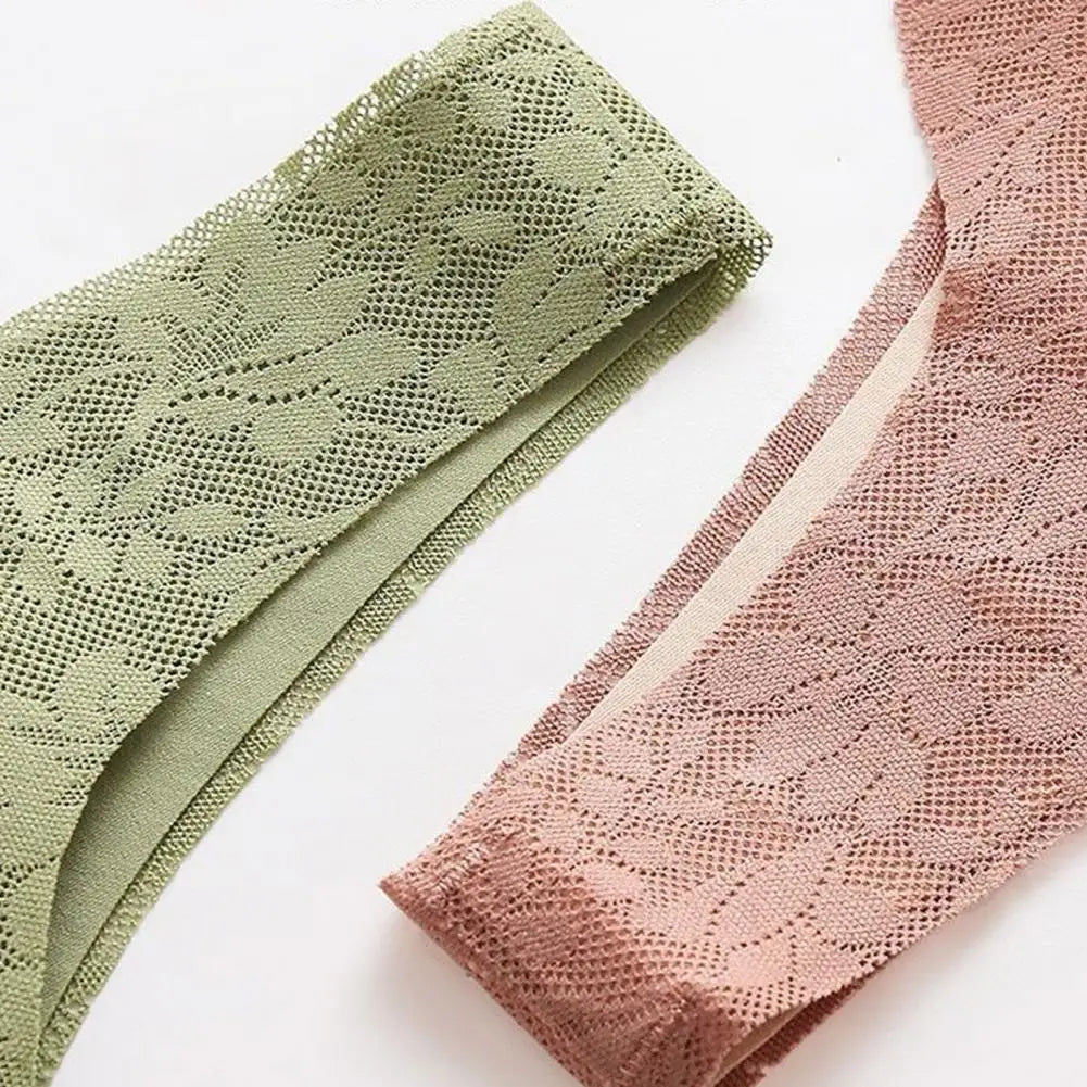Deux culottes en dentelle, une verte et une rose, posées sur une surface blanche. Lingerie féminine élégante et délicate.