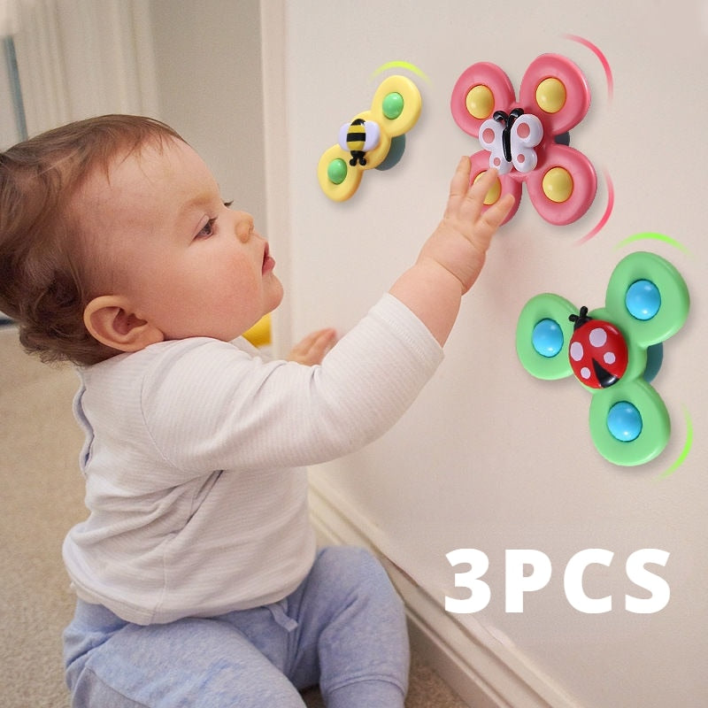 Bébé jouant avec des jouets muraux en forme de papillon et coccinelle, éducatifs et colorés, idéaux pour le développement sensoriel.