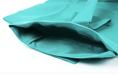 Sac en tissu vert turquoise, ouvert, avec poignées, sur fond blanc. Idéal pour courses écologiques, réutilisable, durable, tendance.