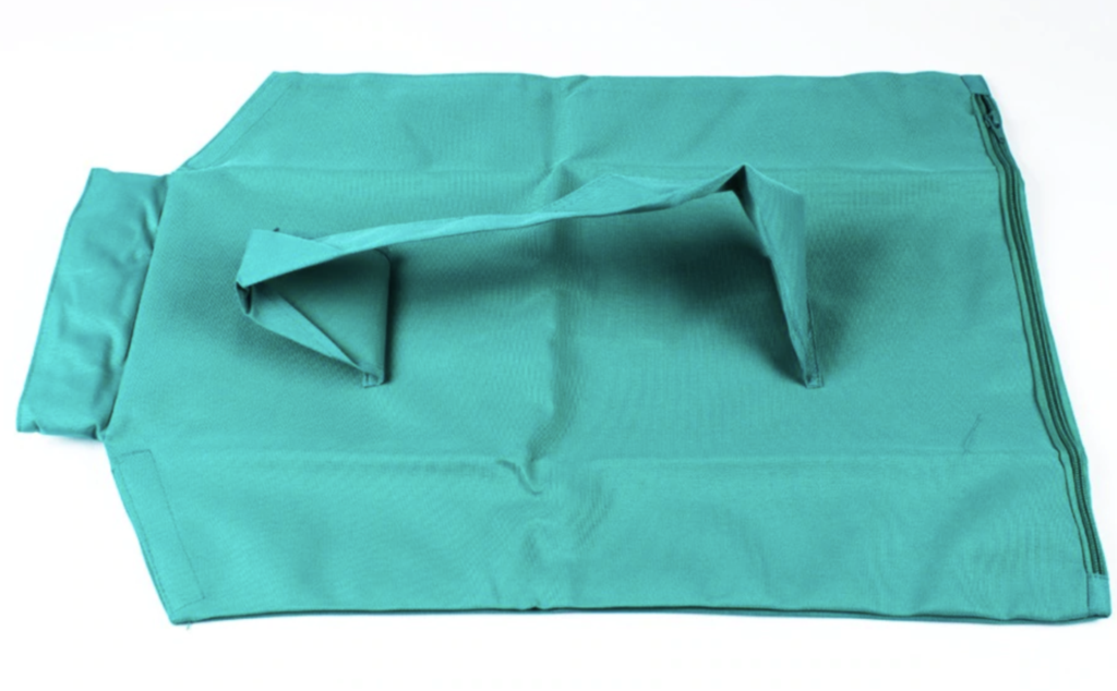 Sac en tissu vert réutilisable, plié avec poignées, sur fond blanc. Accessoire écologique pour courses, mode de vie durable, zéro déchet.