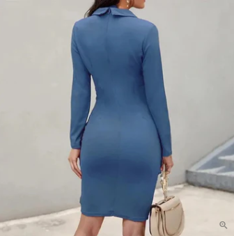 Robe moulante bleue à manches longues, vue de dos, femme tenant un sac beige. Mode élégante, tenue chic, style automne-hiver.