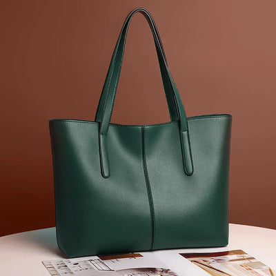 Sac à main en cuir vert foncé élégant sur fond marron, design moderne avec anses longues, idéal pour mode féminine et accessoires tendance.