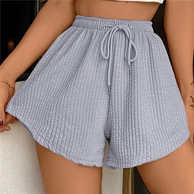 Short en tissu texturé gris clair avec taille élastique et cordon de serrage, mode femme été, style décontracté et confortable.