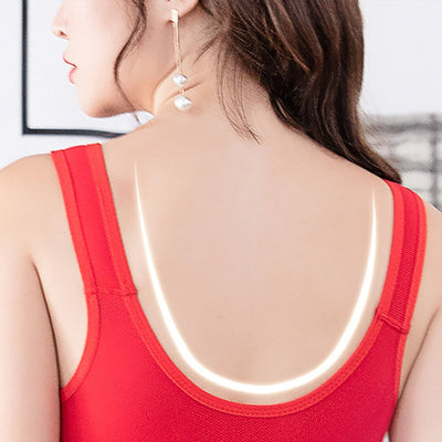 Femme de dos portant un débardeur rouge avec bretelles lumineuses, cheveux bruns ondulés, boucle d'oreille pendante, style moderne et élégant.
