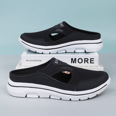 Sabots de sport noirs en maille respirante avec semelle blanche, posés sur des boîtes blanches. Chaussures légères et confortables pour hommes.