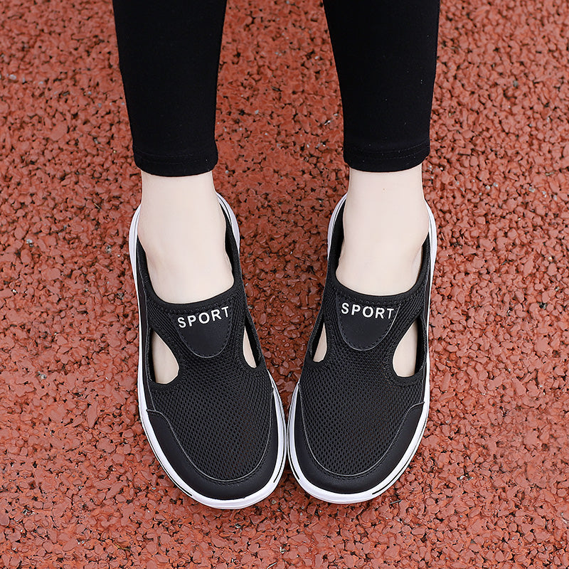 Chaussures de sport noires pour femmes sur fond rouge, design respirant avec découpes, semelle blanche, idéales pour la marche et le fitness.