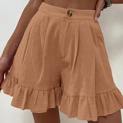 Short en lin beige avec volants, taille haute, bouton central, porté par une femme. Mode estivale, style décontracté, tendance féminine.