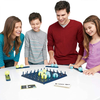 Famille jouant à un jeu de société Bounce-Off, souriant autour d'une table. Jeu de stratégie avec balles et plateau, idéal pour enfants et adultes.