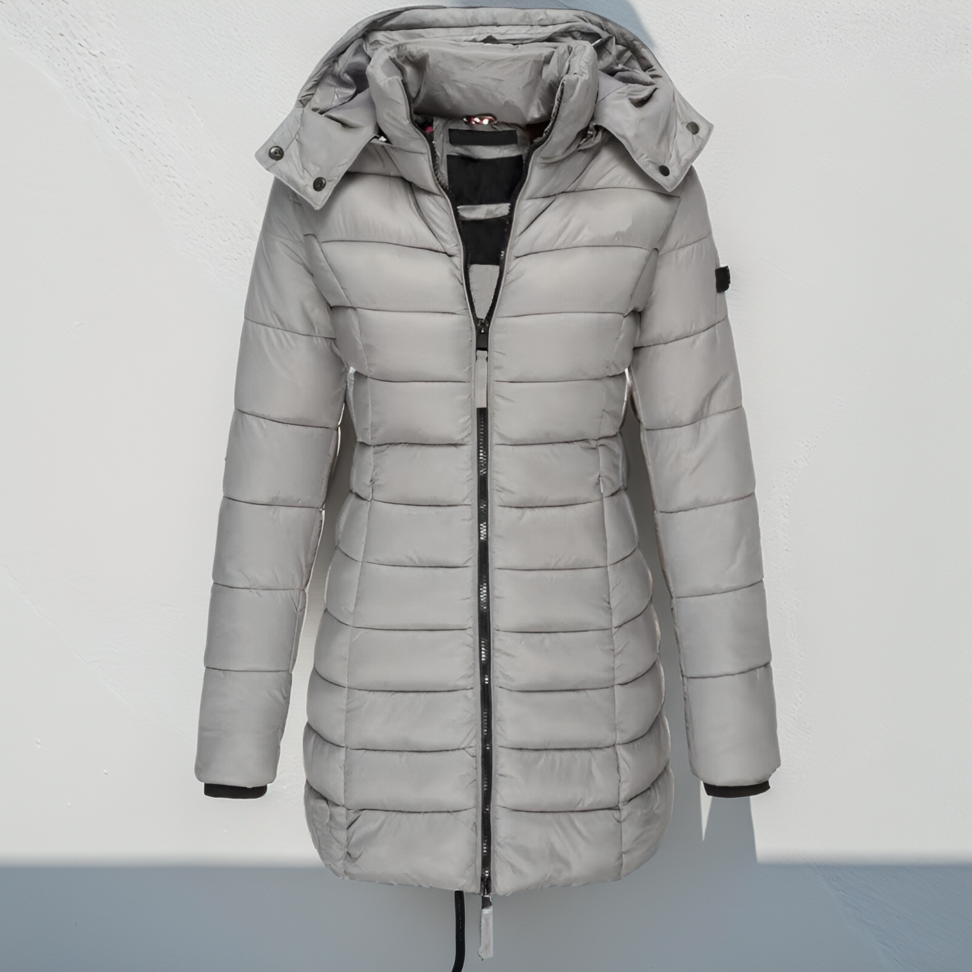 Doudoune grise femme avec capuche, fermeture éclair, design matelassé, idéale pour l'hiver. Mode féminine, manteau chaud, tendance hiver.