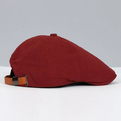 Béret plat rouge en tissu, style rétro, avec sangle réglable en cuir marron. Accessoire de mode élégant pour homme ou femme.