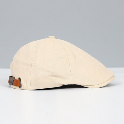Casquette plate beige en coton avec sangle réglable en cuir marron, style rétro. Accessoire de mode élégant pour homme et femme.