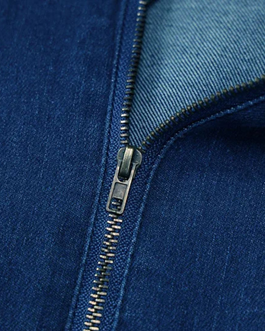 Fermeture éclair en métal sur tissu denim bleu, gros plan. Mode, textile, jean, fermeture éclair robuste, couture précise.