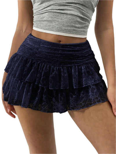 Femme portant une jupe courte en dentelle bleue à volants, associée à un haut gris. Mode féminine, style estival, tenue décontractée.