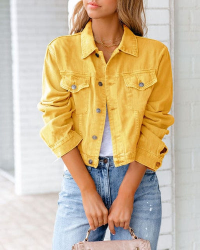 Veste en jean jaune vif pour femme, manches retroussées, portée avec un t-shirt blanc et un jean bleu. Mode tendance, style décontracté.