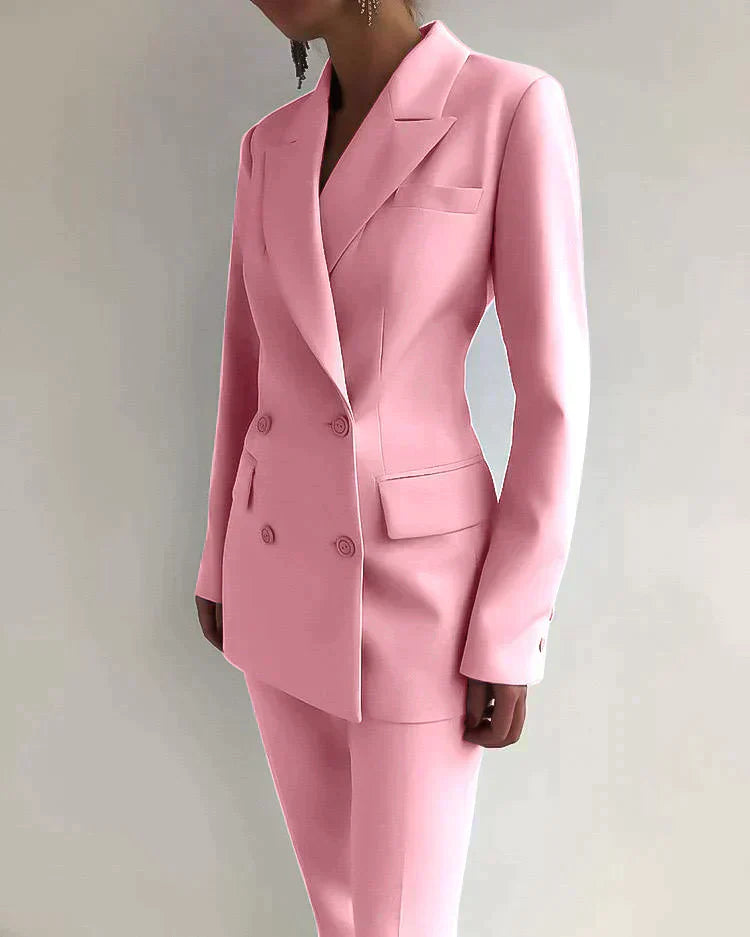 Costume rose élégant pour femme, veste à double boutonnage, pantalon assorti, mode féminine chic, tenue professionnelle moderne.