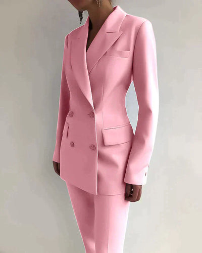 Costume rose élégant pour femme, veste à double boutonnage, pantalon assorti, mode féminine chic, tenue professionnelle moderne.