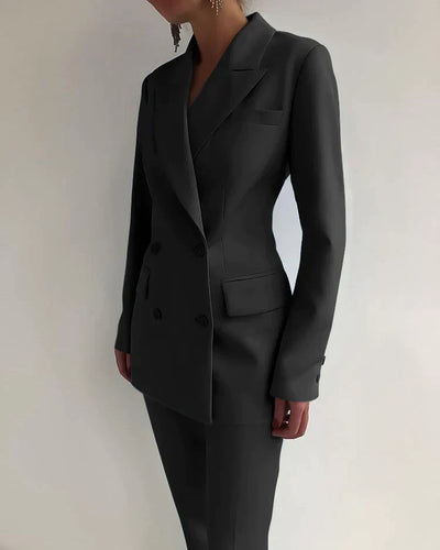 Costume noir élégant pour femme, style moderne et professionnel, avec veste à double boutonnage et pantalon assorti, mode féminine chic.