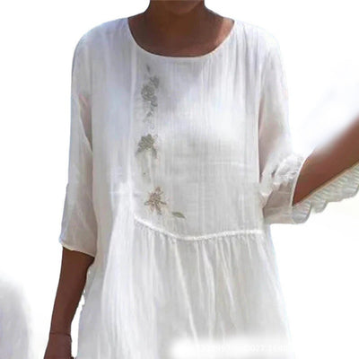 Robe blanche en lin pour femme, manches trois-quarts, broderie florale délicate sur le devant, style bohème chic, tenue estivale élégante.
