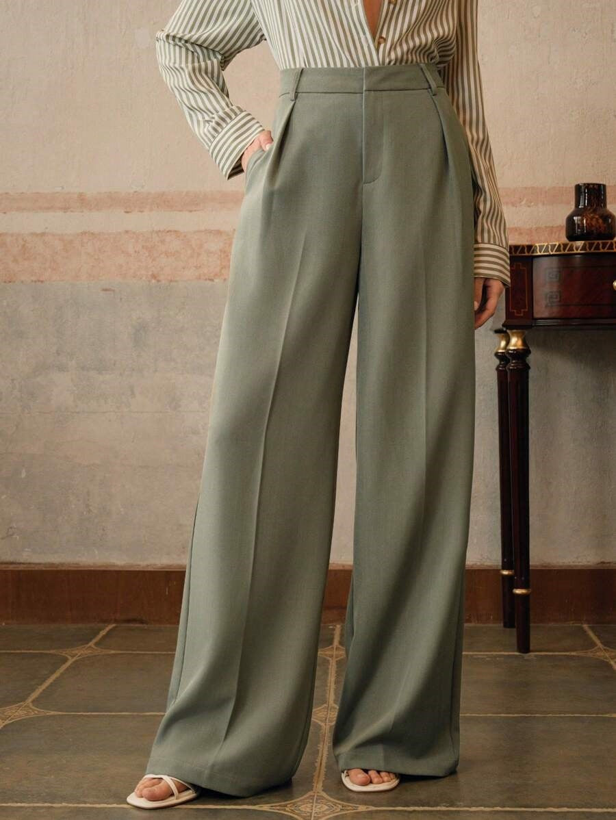 Pantalon large vert olive taille haute, élégant et moderne, porté avec une chemise rayée. Mode féminine chic et tendance.