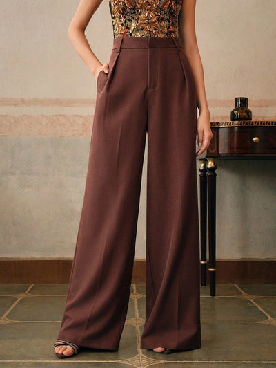Pantalon large marron pour femme, taille haute, élégant, avec poches, porté avec un haut sans manches à motifs, style chic et moderne.