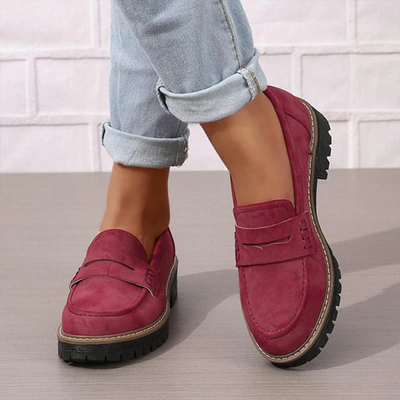 Chaussures mocassins rouges pour femme, en daim, avec semelle épaisse noire, portées avec un jean retroussé. Mode féminine, chaussures tendance.
